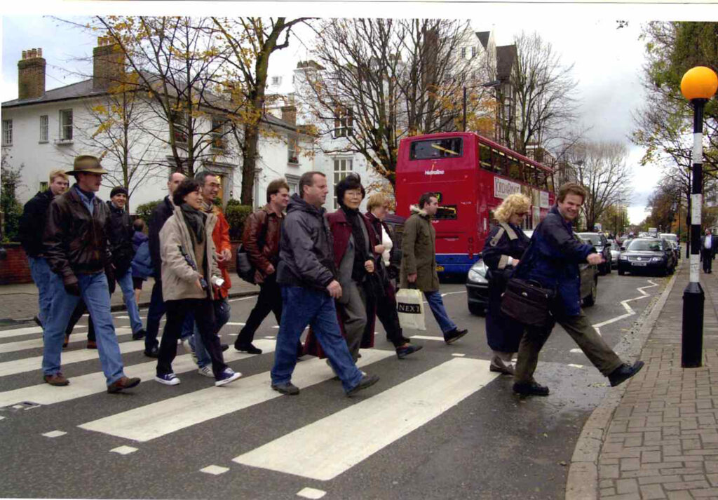 Guide Richard Porter and his tour group crossing Abbey Road - as the Beatles did in 1969